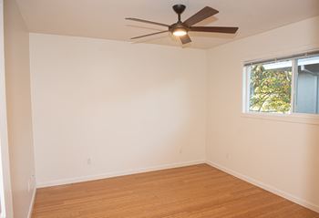 Empty room with a ceiling fan and a window.